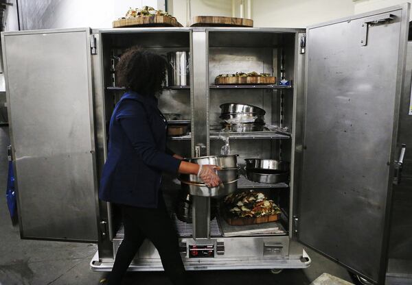 Sundus Duale, an employee of Goodr, cleans up empty trays on Friday, Jan. 24, 2020, at the Georgia World Congress Center in Atlanta. Goodr collects leftover food from businesses and delivers them to local nonprofits with the goal of reducing food waste and food insecurity in and around Atlanta. CHRISTINA MATACOTTA / CRMATACOTTA@GMAIL.COM