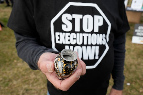 Randy Gardner, hold the ashes of his brother Ronnie the last death row inmate to be executed by firing squad during a protest outside the execution of South Carolina inmate Brad Sigmon, Friday, March 7, 2025, in Columbia, S.C. (AP Photo/Chris Carlson)