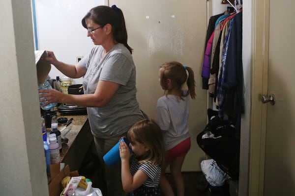 Rimbey Schroeder (left) gets water for her daughters Sarah (right) and Elizabeth (middle). CHRISTINA MATACOTTA / CHRISTINA.MATACOTTA@AJC.COM