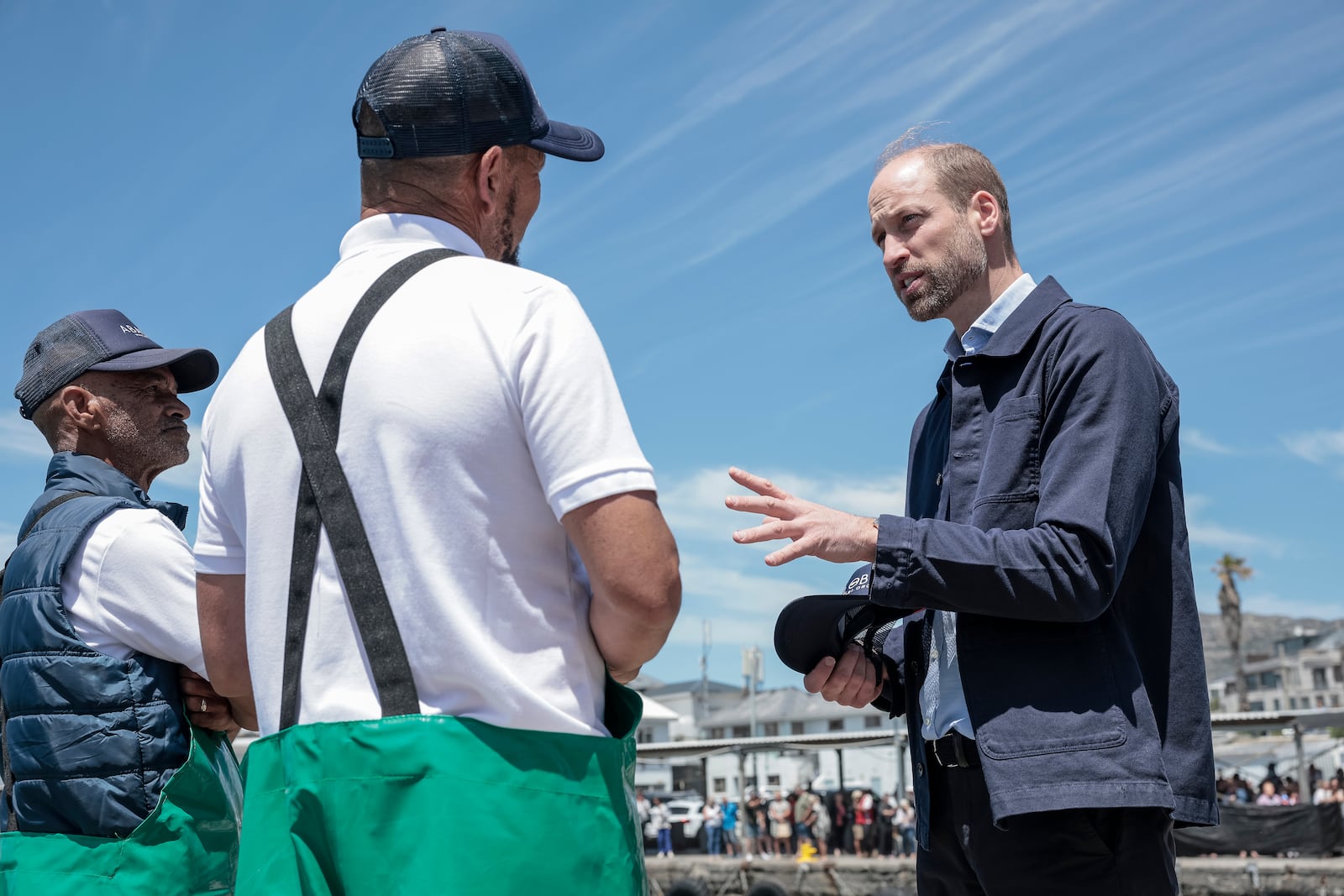 Britain's Prince William, right, speaks to local fisherman in Kalk Bay Harbour, near Cape Town, South Africa Thursday, Nov. 7, 2024. (Gianluigi Guercia/Pool Photo via AP)