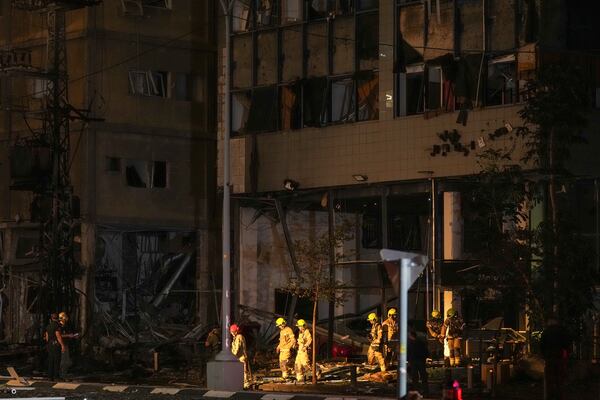 Firemen exit a building damaged by a rocket attack in Ramat Gan, Tel Aviv district, Monday Nov. 18, 2024. A rocket hit the area following sirens and interceptions of projectiles authorities said. At least five people were reported injured. (AP Photo Francisco Seco)