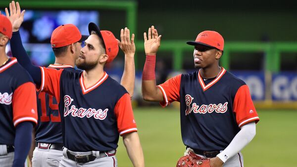 Ronald Acuna Jr. #13 of the Atlanta Braves high fives teammates after defeating the Miami Marlins at Marlins Park on August 26, 2018 in Miami, Florida. All players across MLB will wear nicknames on their backs as well as colorful, non-traditional uniforms featuring alternate designs inspired by youth-league uniforms during Players Weekend. (Photo by Eric Espada/Getty Images)