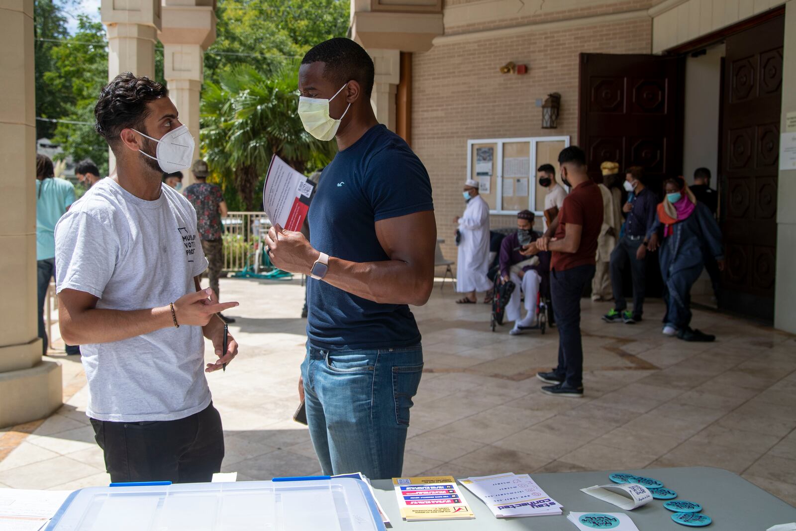 Georgia Muslim Voter Project Community Organizer Salik Sohani, left, speaks with Ben Coulibaly about voter registration following prayer outside of the Al-Farooq Masjid in downtown Atlanta in August 2021. (Alyssa Pointer/Atlanta Journal Constitution)