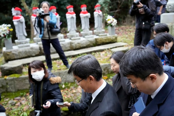 South Korean Ambassador to Japan Park Cheol-hee, bottom left, leaves after a memorial service with the relatives of Korean victims and South Korean officials at the site of former Fourth Souai Dormitory for the mine workers from the Korean Peninsula, in Sado, Niigata prefecture, Japan, Monday, Nov. 25, 2024, a day after boycotting a memorial organized by Japanese officials. (AP Photo/Eugene Hoshiko)