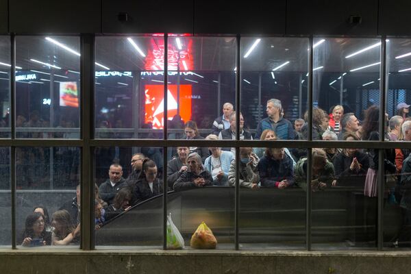 People take shelter from the rain at a pedestrian underpass as they await the arrival of university students at a protest ahead of a major anti-corruption rally this weekend, in Belgrade, Serbia, Friday, March 14, 2025. (AP Photo/Marko Drobnjakovic)