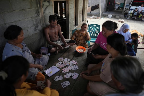 People play cards in Budong-Budong, West Sulawesi, Indonesia, Monday, Feb. 24, 2025. (AP Photo/Dita Alangkara)