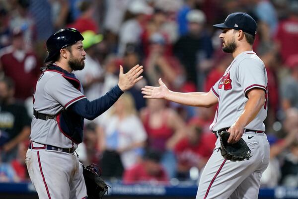 Atlanta Braves catcher Travis d'Arnaud, left, and pitcher Brad Hand celebrate after the Braves won a baseball game against the Philadelphia Phillies, Tuesday, Sept. 12, 2023, in Philadelphia. (AP Photo/Matt Slocum)