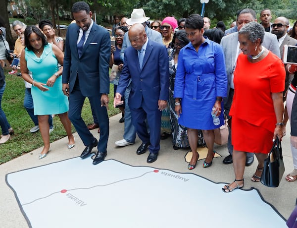 U.S. Rep. John Lewis, along with council member Andre Dickens, who introduced the ordinance to honor Lewis and Mayor Keisha Lance Bottoms, stop to look at one of the states painted on the John Lewis Ride to Freedom Play Space on the way to the sign unveiling.   