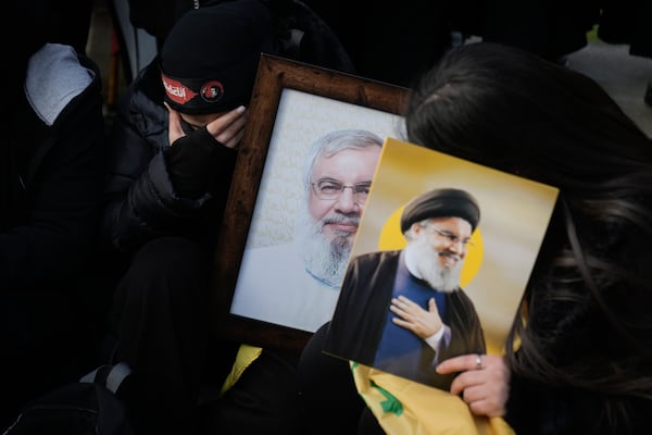 Mourners hold pictures of Hezbollah's former leader Hassan Nasrallah, right, and his cousin and successor Hashem Safieddine as they gather to attend their funeral procession in Beirut, Lebanon, Sunday Feb. 23, 2025. (AP Photo/Bilal Hussein)