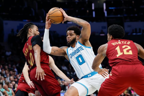 Charlotte Hornets forward Miles Bridges (0) drives to the basket between Cleveland Cavaliers guard Darius Garland (10) and forward De'Andre Hunter (12) during the second half of an NBA basketball game in Charlotte, N.C., Friday, March 7, 2025. (AP Photo/Nell Redmond)