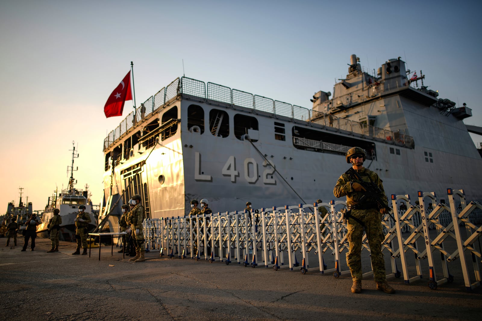 Turkish security personnel stand guard next to Turkish military ships preparing to evacuate citizens from Lebanon to Turkey in Beirut port on Wednesday, Oct. 9, 2024. (AP Photo/Emrah Gurel)