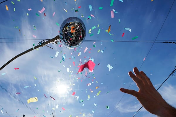 FILE - A Societe de Sainte Anne parade goer reaches for confetti during Mardi Gras in New Orleans, March 1, 2022. (AP Photo/Gerald Herbert, File)