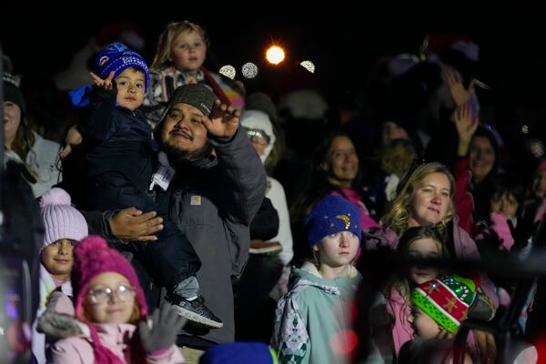 People wave to Santa Claus during a visit of theCSX Holiday Express, Thursday, Nov. 21, 2024, in Erwin, Tenn. (AP Photo/George Walker IV)