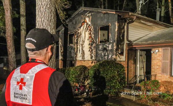 American Red Cross volunteer Jim Tudor stands in front of the scene of a deadly house fire on Kimball Road. JOHN SPINK / JSPINK@AJC.COM