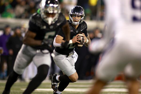 Oregon quarterback Dillon Gabriel (8) looks for an opening during an NCAA college football game against Washington, Saturday, Nov. 30, 2024, in Eugene, Ore. (AP Photo/Lydia Ely)