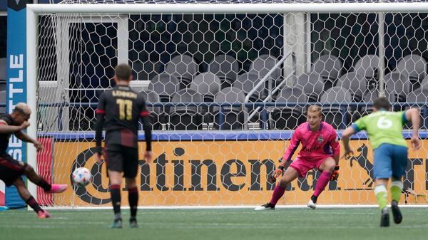 Atlanta United forward Josef Martinez (left) kicks a penalty-kick goal on Seattle Sounders goalkeeper Stefan Cleveland during the second half Sunday, May 23, 2021, in Seattle. The match ended in a 1-1 draw. (Ted S. Warren/AP)