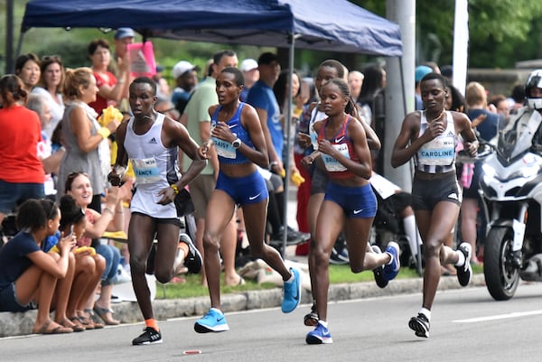 Female elite runners including Brigid Kosgei (red) challenge up Cardiac Hill near Shepherd Center during the 50th AJC Peachtree Road Race on Thursday, July 4, 2019. (Hyosub Shin / Hyosub.Shin@ajc.com)