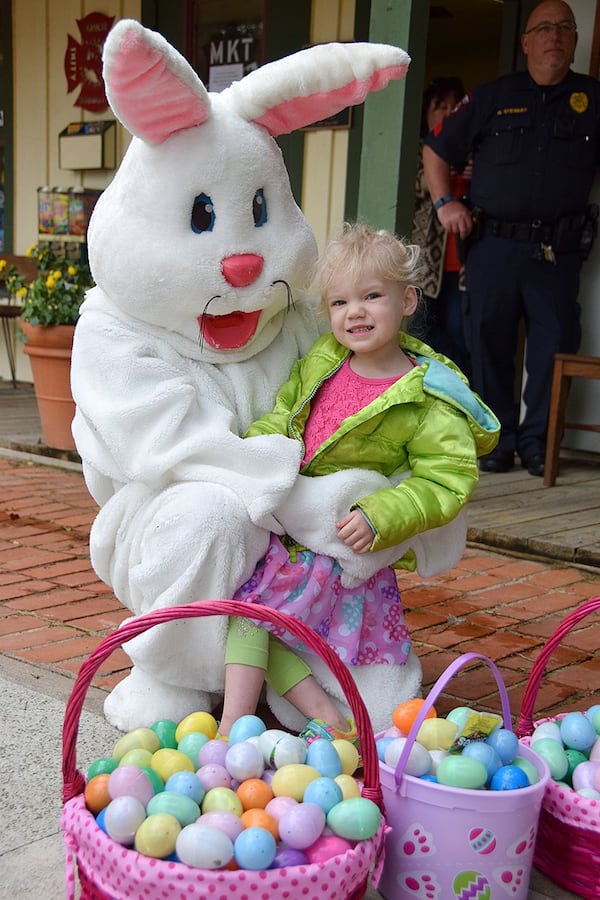 Aryah Amidon happily poses with the Easter Bunny and baskets of eggs from the hunt. PHOTO BY FRAN HUNTER FOR SMITHVILLE TIMES MARCH 25, 2016