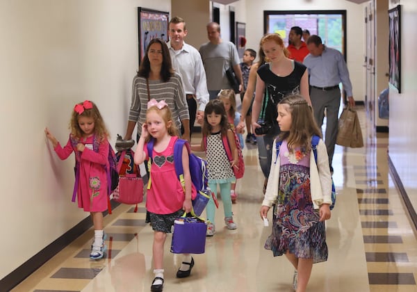 August 11, 2014 - Milton - On the first day of school at Birmingham Falls Elementary in Milton students and their parents head to their new classrooms. BOB ANDRES / BANDRES@AJC.COM Should parents of children with summer birthdays delay their entrance into kindergarten so they are not the youngest in the class? BOB ANDRES / BANDRES@AJC.COM