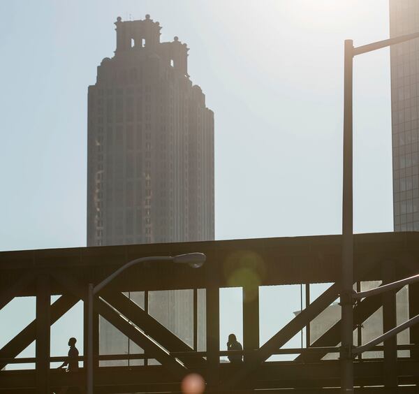 Clear skies allow the sun to shine throughout downtown Atlanta as people walk through the CNN pedestrian bridge Thursday. A high of 91 degrees has put much of metro Atlanta under a Code Orange smog alert. ALYSSA POINTER/ALYSSA.POINTER@AJC.COM