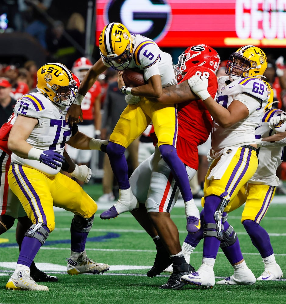 LSU Tigers quarterback Jayden Daniels (5) is manhandled by Georgia Bulldogs defensive lineman Jalen Carter (88) during the second half of the SEC Championship Game at Mercedes-Benz Stadium in Atlanta on Saturday, Dec. 3, 2022. (Bob Andres / Bob Andres for the Atlanta Constitution)