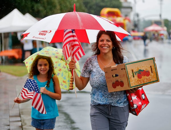 Doreen Row (right) and her daughter, Rachel, 8, didn't let the weather dampen their spirits. Rain dampened the turnout for the 22nd annual Marietta Streetfest held on the Marietta Square Saturday. The event is a fundraiser for the Marietta Museum of History and featured antique dealers and artists, the Marietta Square Farmers Market, the Hubcaps and History Marietta Classic Car Show and the Marietta Grassroots Music Festival.