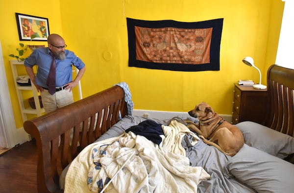 Immigration attorney Marty Rosenbluth plays with his dog, Salsa, in the guest room of his home in Lumpkin, Ga. On average, Rosenbluth said, he represents 10 to 15 immigrants at a time at Stewart Detention Center. “This type of work is not something you do. It has to be somebody you are. This who I am,” said Rosenbluth. HYOSUB SHIN / HSHIN@AJC.COM