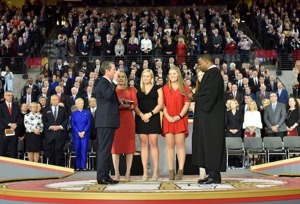 Brian Kemp takes the oath of office to become Georgia’s 83rd governor while his wife, Marty, holds the Bible and his daughers look on. Judge T.J. Hudson is administering the oath. Photo: Hyosub Shin / Hyosub.Shin@ajc.com