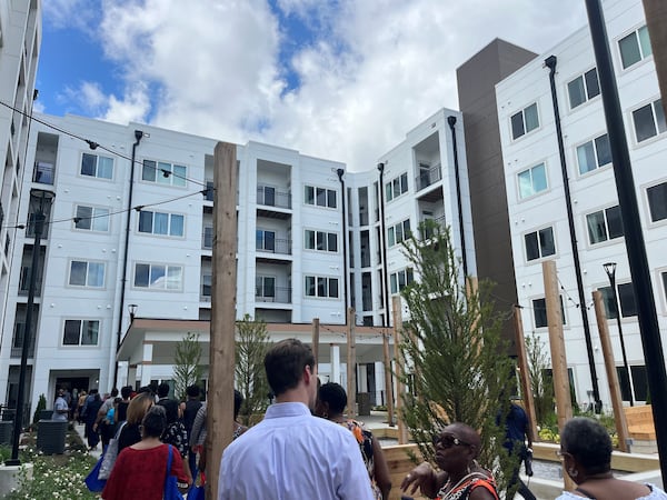 Community members tour Briar Park's outdoor living space, which includes fire pits and bocce ball courts.