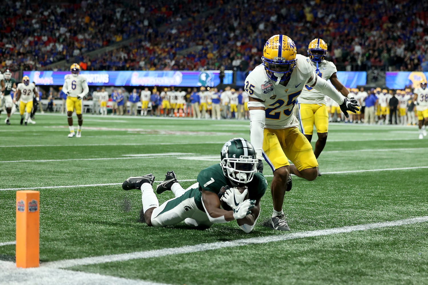 Michigan State Spartans wide receiver Jayden Reed (1) scores a receiving touchdown against Pittsburgh Panthers defensive back A.J. Woods (25) during the first half of the Chick-fil-A Peach Bowl at Mercedes-Benz Stadium in Atlanta, Thursday, December 30, 2021. JASON GETZ FOR THE ATLANTA JOURNAL-CONSTITUTION