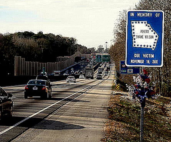 A sign on the the shoulder of the westbound lanes of I-20 near Panola Road commemorates Robert Shane Wilson, a Doraville police officer who was answering a call when a driver heading the wrong way on the interstate hit him. Police charged the motorist with driving under the influence.