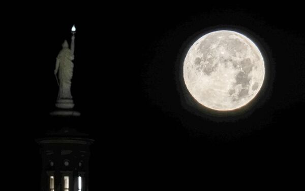 The first full moon of 2023 sets over the Georgia State Capitol building. (John Spink / john.spink@ajc.com)