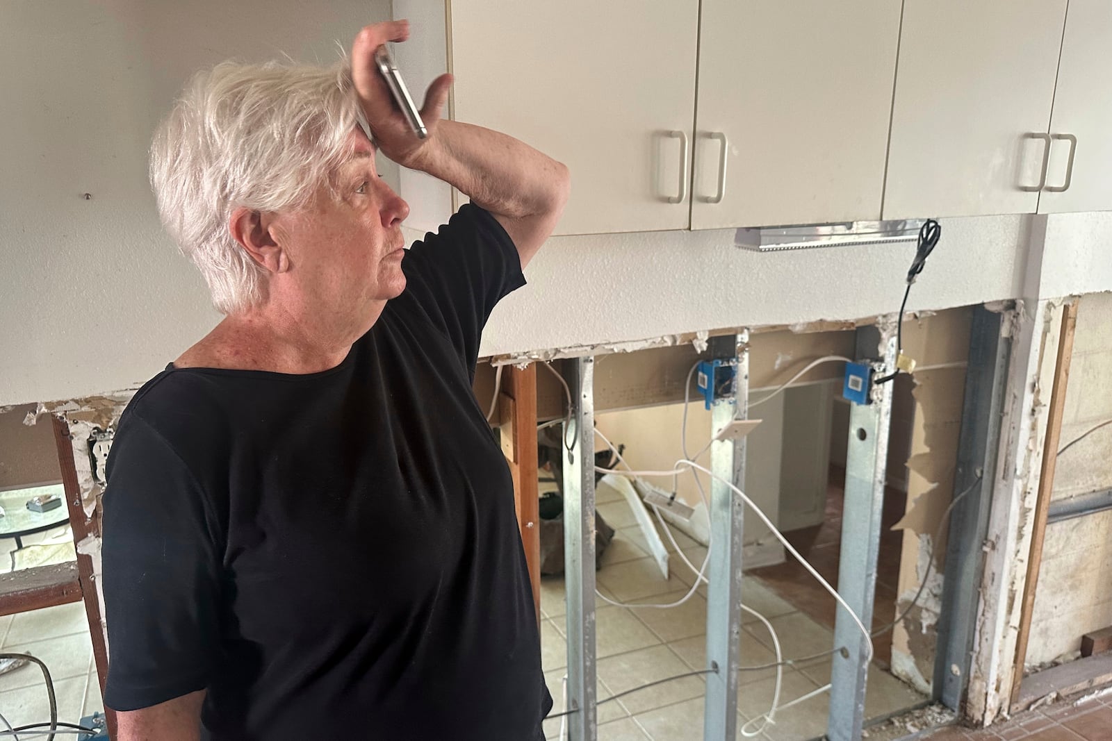 Catherine Praught stands inside her damaged home from Hurricane Milton in Cortez, Fla., on Saturday, Oct. 12, 2024. (AP Photo/Russ Bynum)