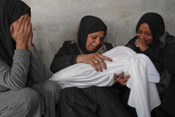 Naanaa Abu Aker holds the body of her 2-year-old niece Salma, killed during an Israeli army strike, before their burial at the Baptist hospital in Gaza City, Monday March 24, 2025.(AP Photo/Jehad Alshrafi)