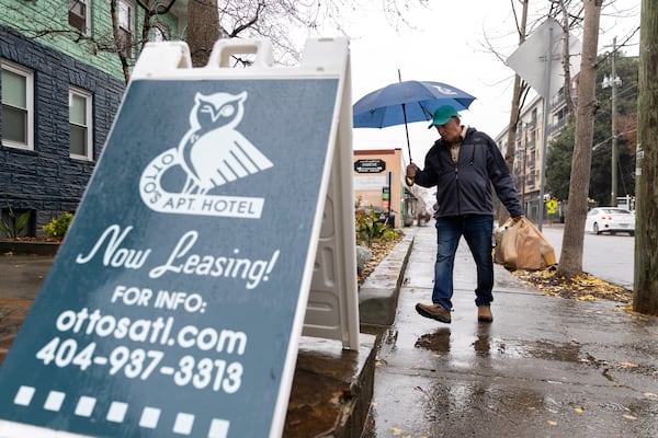 A man walks toward Otto’s Apartment Hotel in Atlanta on Monday, Dec. 9, 2024. (Arvin Temkar/AJC)