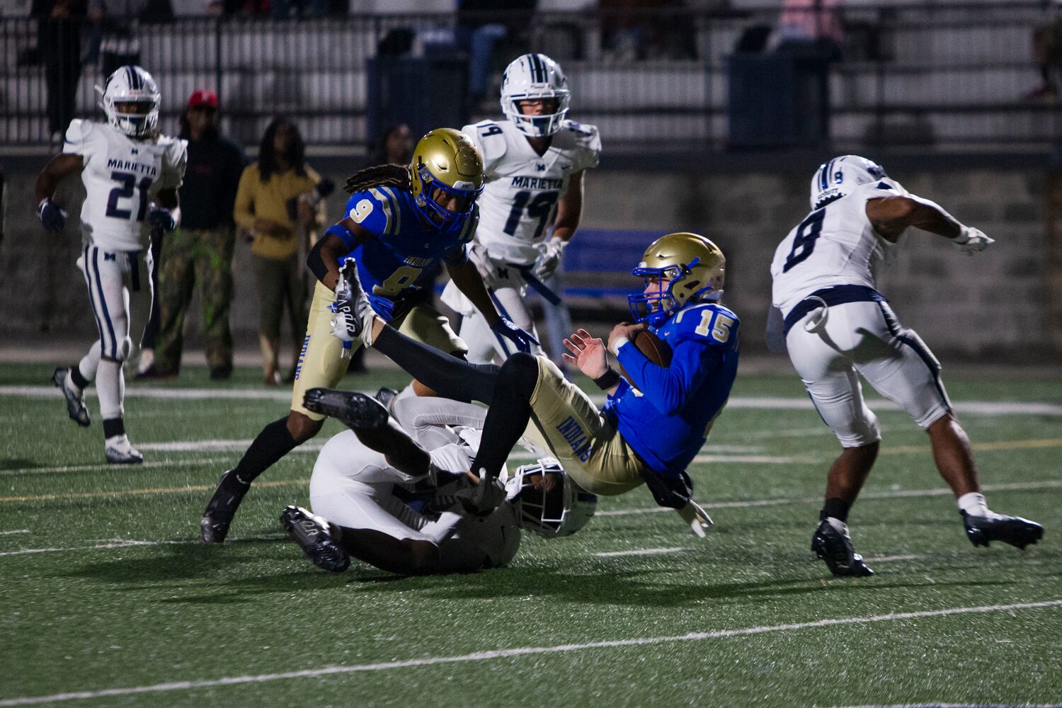 Adrian Martinez, punter for McEachern, gets tackled during the Marietta vs. McEachern High School Football game on Friday, October 14, 2022, at McEachern High School in Powder Springs, Georgia. Marietta defeated McEachern 34-16.  CHRISTINA MATACOTTA FOR THE ATLANTA JOURNAL-CONSTITUTION.