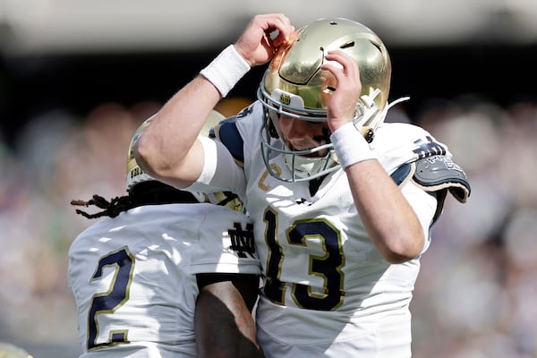 Notre Dame quarterback Riley Leonard (13) celebrates after scoring a touchdown during the first half of an NCAA college football game against Navy Saturday, Oct. 26, 2024, in East Rutherford, N.J. (AP Photo/Adam Hunger)