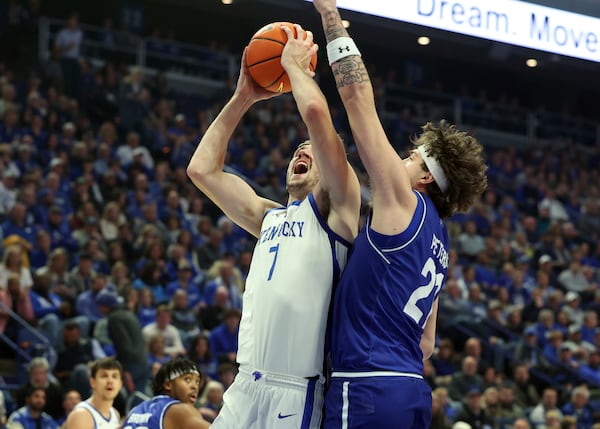 Kentucky's Andrew Carr (7) shoots while defended by Georgia State's Clash Peters, right, during the first half of an NCAA college basketball game in Lexington, Ky., Friday, Nov. 29, 2024. (AP Photo/James Crisp)