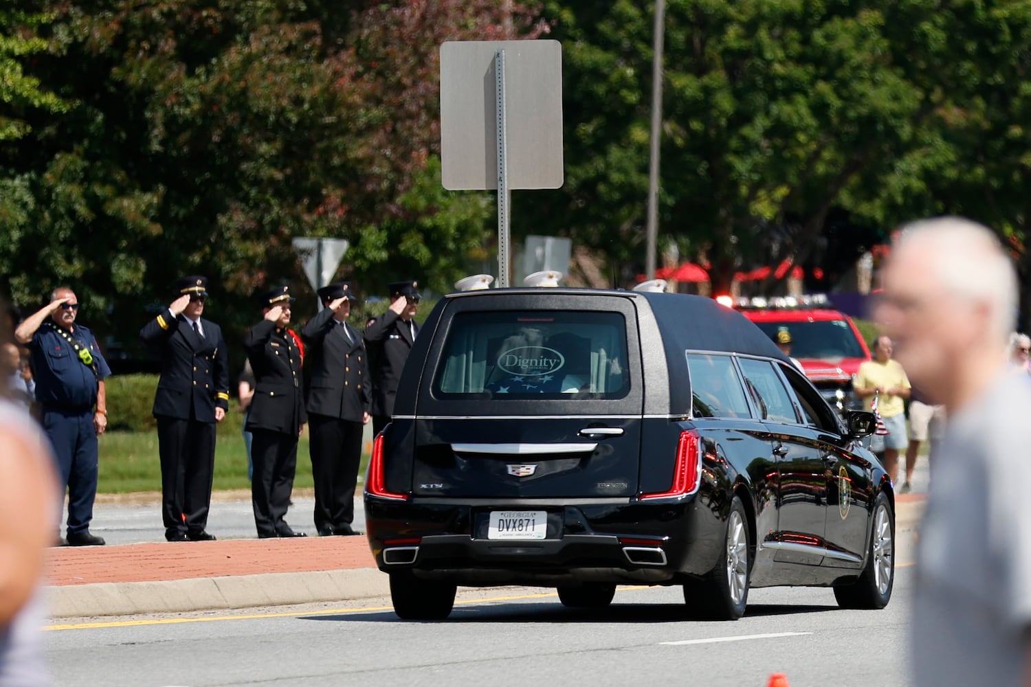 Members of the Cobb County Firefighter department salute the hearse of fallen Deputy Jonathan Koleski as the procession passes on Chastain Road on Wednesday, September on Wednesday, September 14, 2022. Miguel Martinez / miguel.martinezjimenez@ajc.com 