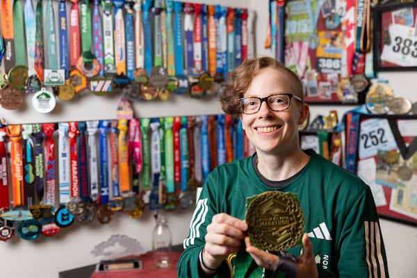 Caroline Burnet poses for a portrait at her home in Atlanta on Friday, February 28, 2025. Burnet will be running her 200th marathon. (Arvin Temkar / AJC)