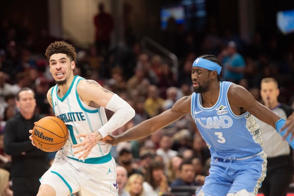 Charlotte Hornets' LaMelo Ball (1) drives past Cleveland Cavaliers' Caris LeVert (3) during the second half of an NBA basketball game in Cleveland, Sunday, Nov 17, 2024. (AP Photo/Phil Long)