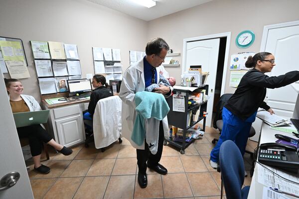 Dr. Jeffrey Harris shows Prince Jasper Lee Holder, 16 days old, to staff at his medical practice, Wayne Obstetrics and Gynecology in Jesup in southeast Georgia. Prince’s mother, Joy Holder, was in a nearby room for a check-in appointment on Feb. 6, 2020. (Hyosub Shin / Hyosub.Shin@ajc.com)