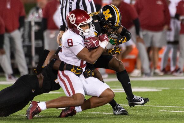 Oklahoma running back Taylor Tatum (8) his tackled by Missouri safety Marvin Burks Jr., right, during the first half of an NCAA college football game Saturday, Nov. 9, 2024, in Columbia, Mo. (AP Photo/L.G. Patterson)