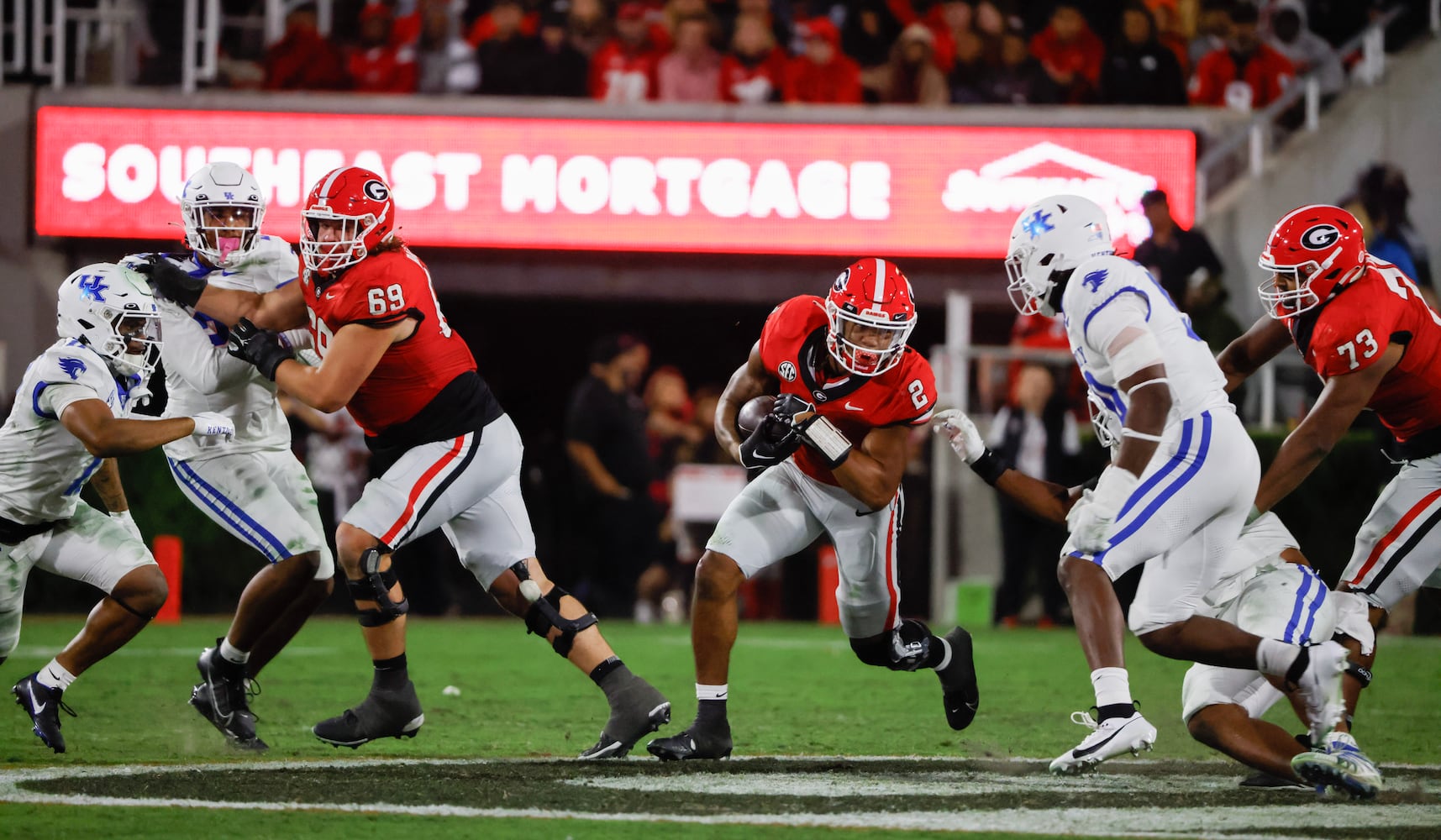  Georgia Bulldogs running back Kendall Milton (2) runs for a first down with blocking from offensive lineman Tate Ratledge (69) and offensive lineman Xavier Truss (73) during the second half.  (Bob Andres for the Atlanta Journal Constitution)