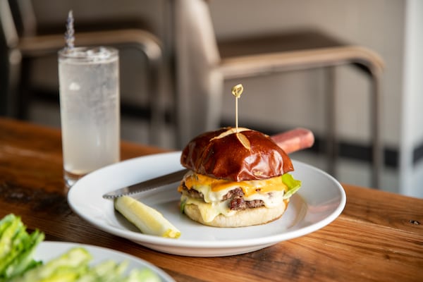 Emmy Squared's Le Big Matt with double-stack grass-fed beef patties, American cheese, Sammy Sauce, greens and pickles on a pretzel bun. Mia Yakel for The AJC