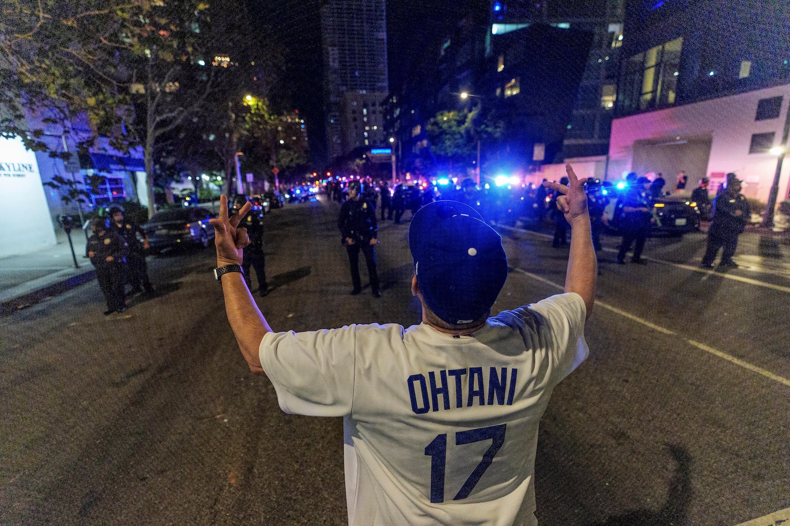 A fan wearing a Shohei Ohtani taunts Los Angeles Police officers as fans celebrate on the streets after the Los Angeles Dodgers won against the New York Yankees in the baseball World Series Wednesday, Oct. 30, 2024, in downtown Los Angeles. (AP Photo/Damian Dovarganes)