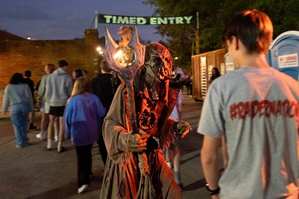 A “lot monster” scares people arriving at Netherworld haunted house in Stone Mountain on Friday, Oct. 25, 2024.   Ben Gray for the Atlanta Journal-Constitution