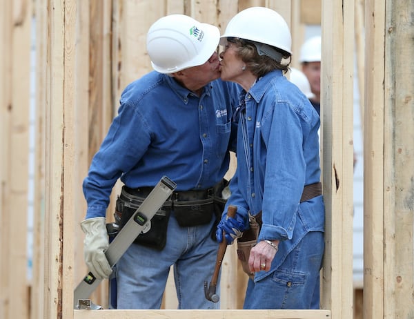 2015: Jimmy Carter sneaks a kiss with Rosalynn while the couple works on a Habitat for Humanity build in Memphis in 2015. (Ben Gray / bgray@ajc.com)