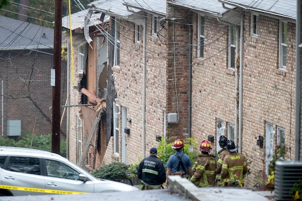 Fire officials look at the scene where an airplane crashed into an apartment complex, Wednesday, Oct. 30, 2019, in Atlanta.