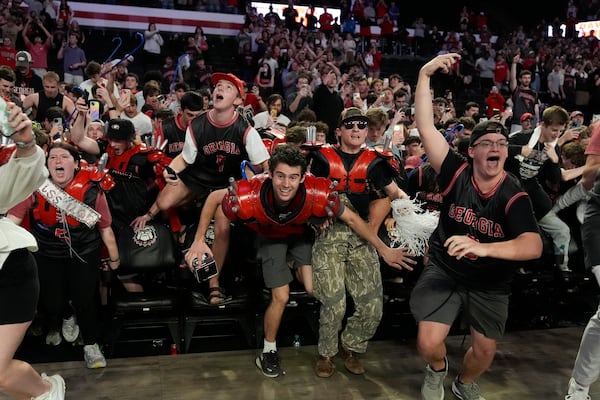 Georgia fans rush the court in celebration after an NCAA college basketball game against Florida, Tuesday, Feb. 25, 2025, in Athens, Ga. (AP Photo/Brynn Anderson)